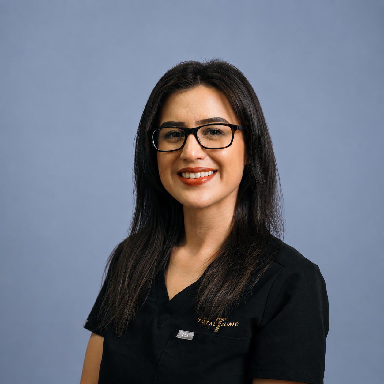 A woman with long dark hair, glasses, and a black uniform smiling at the camera against a blue background.