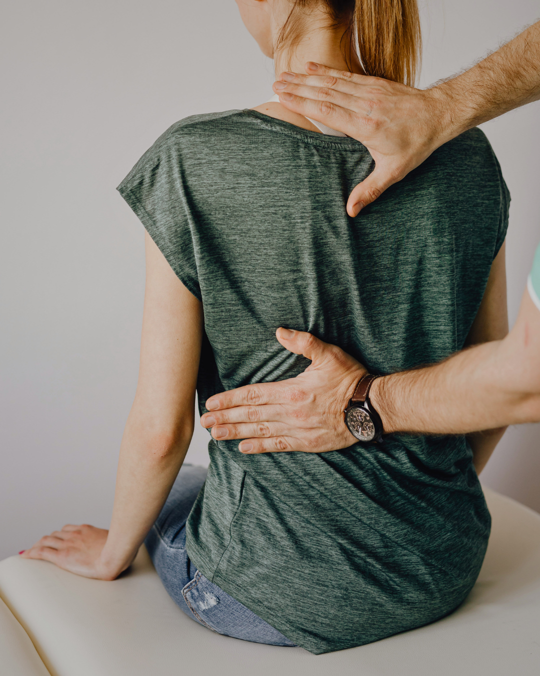 A person receiving chiropractic or medical treatment on their neck and back from a healthcare professional.