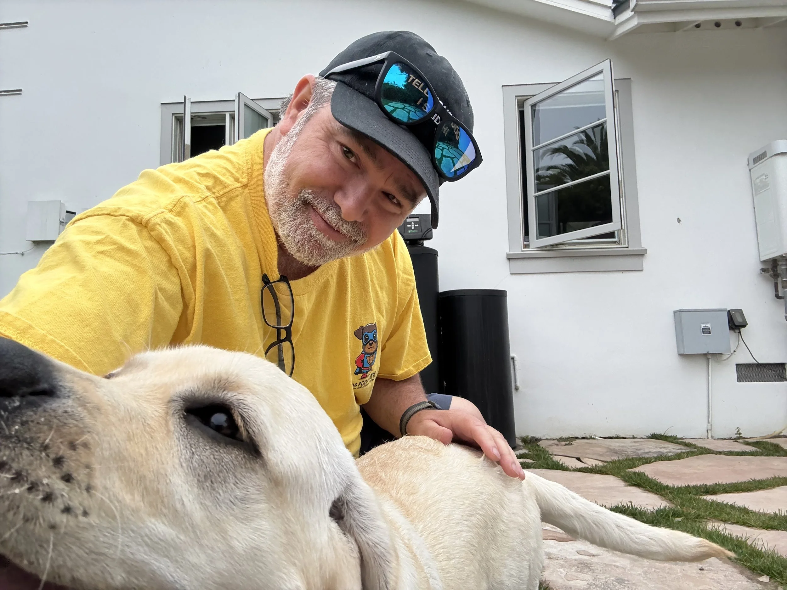 Marc Holden, founder of 805 Poop Patrol, smiling and petting a dog