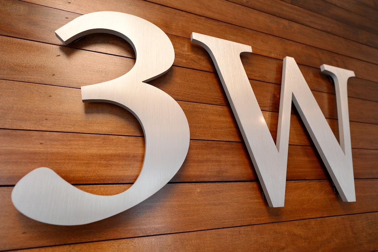 Silver 3M logo on a wooden wall.