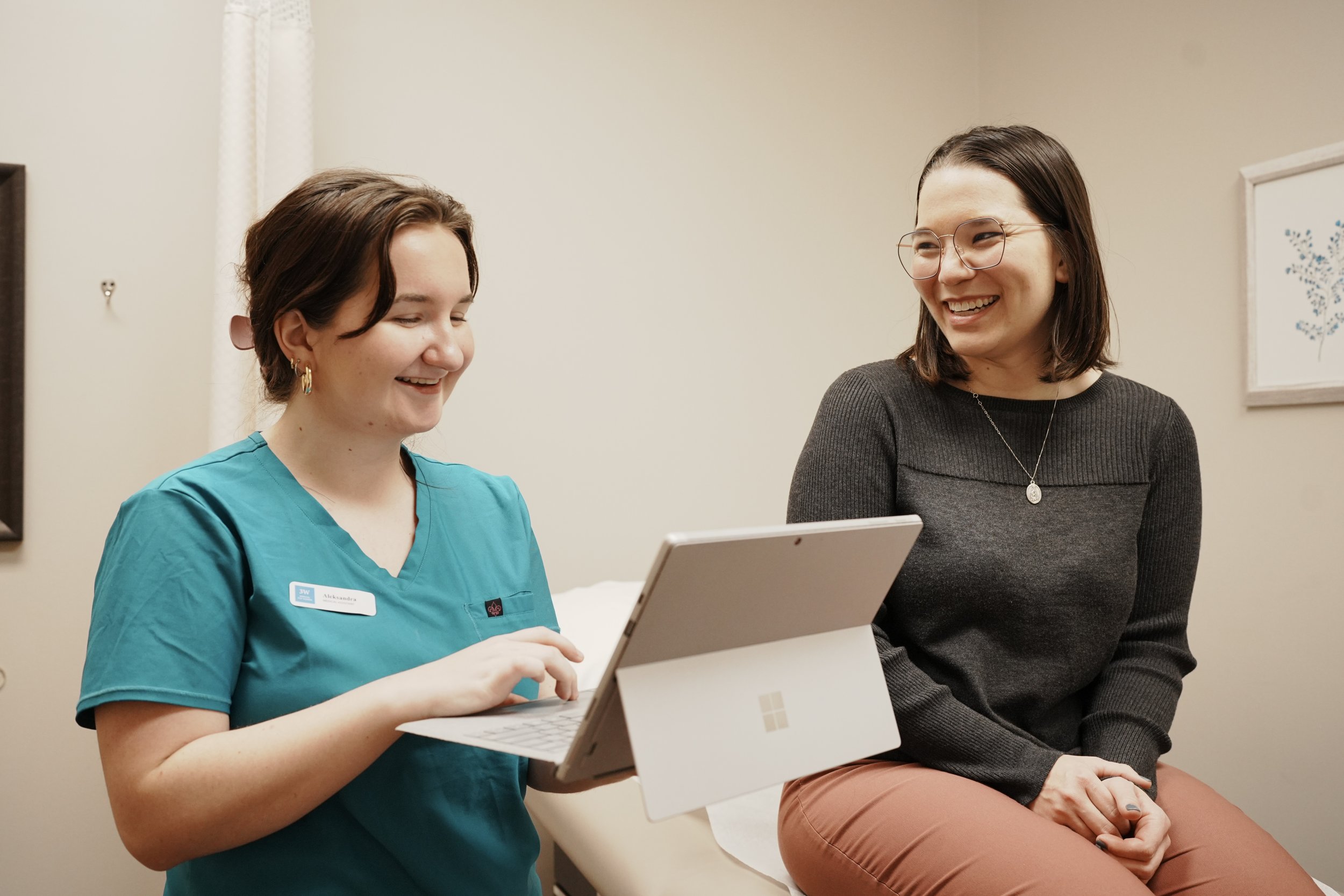 A healthcare worker and a woman sitting and chatting in a medical office