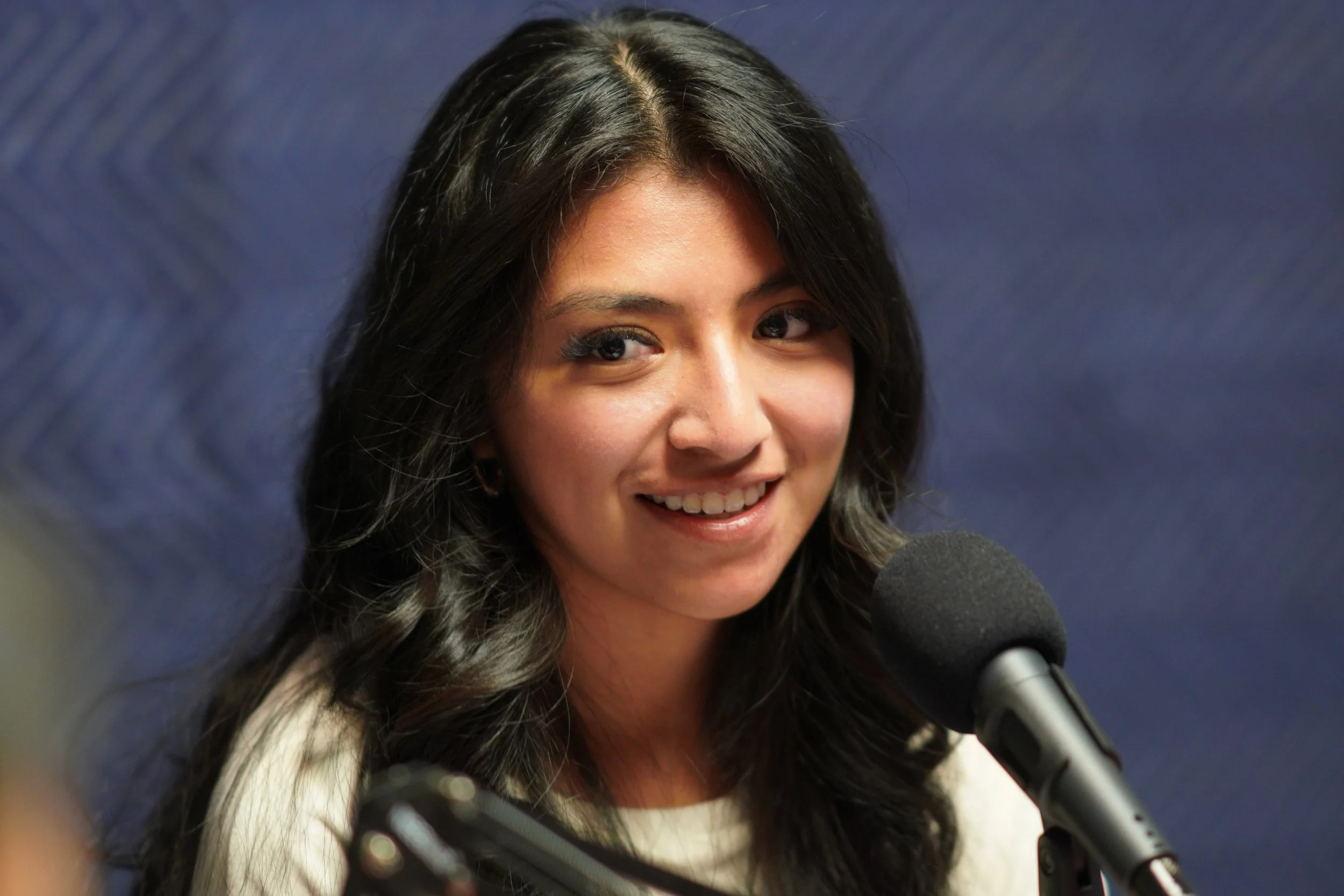 Photo of woman speaking into microphone.
