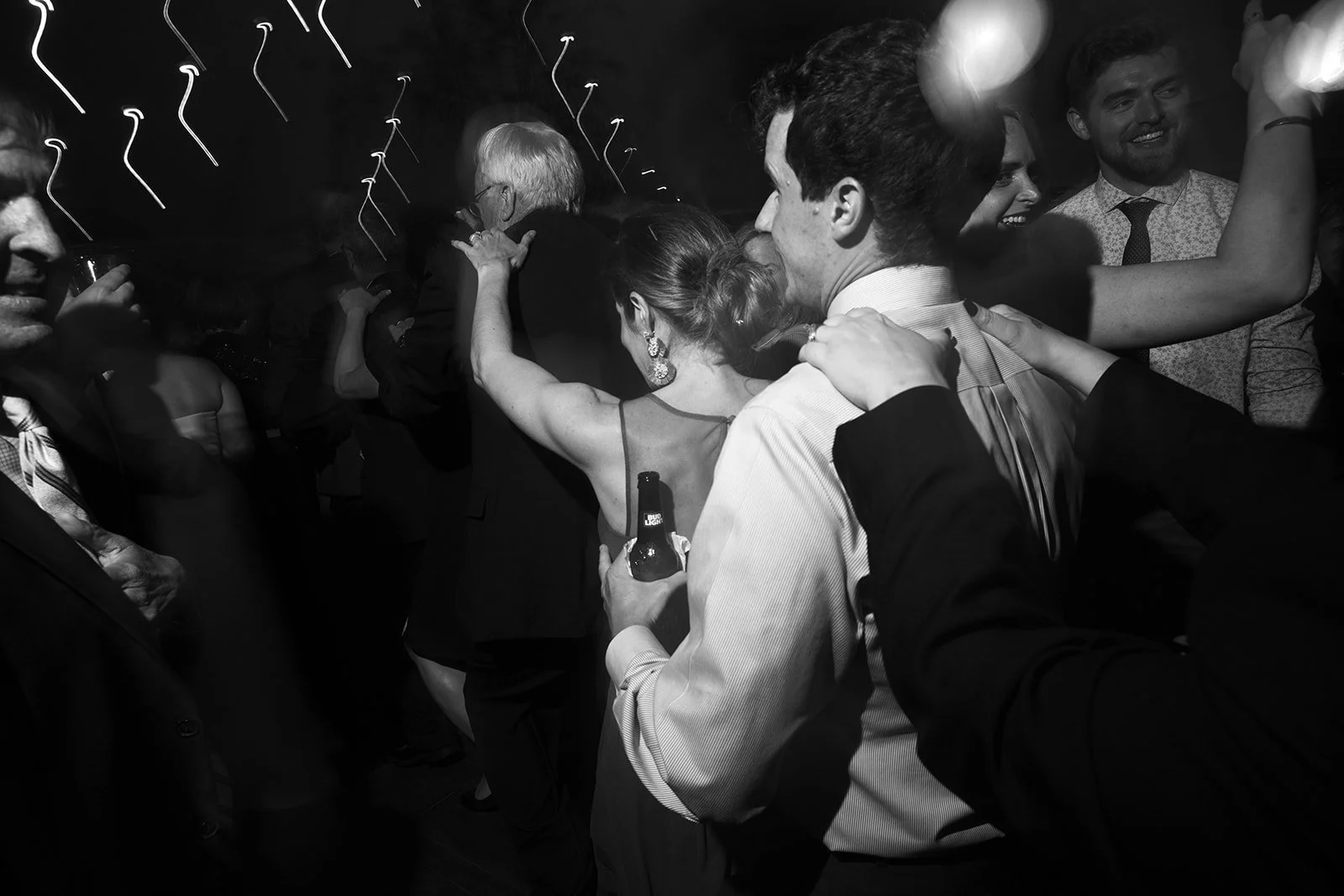 People dancing and socializing at a party, in black and white photograph.