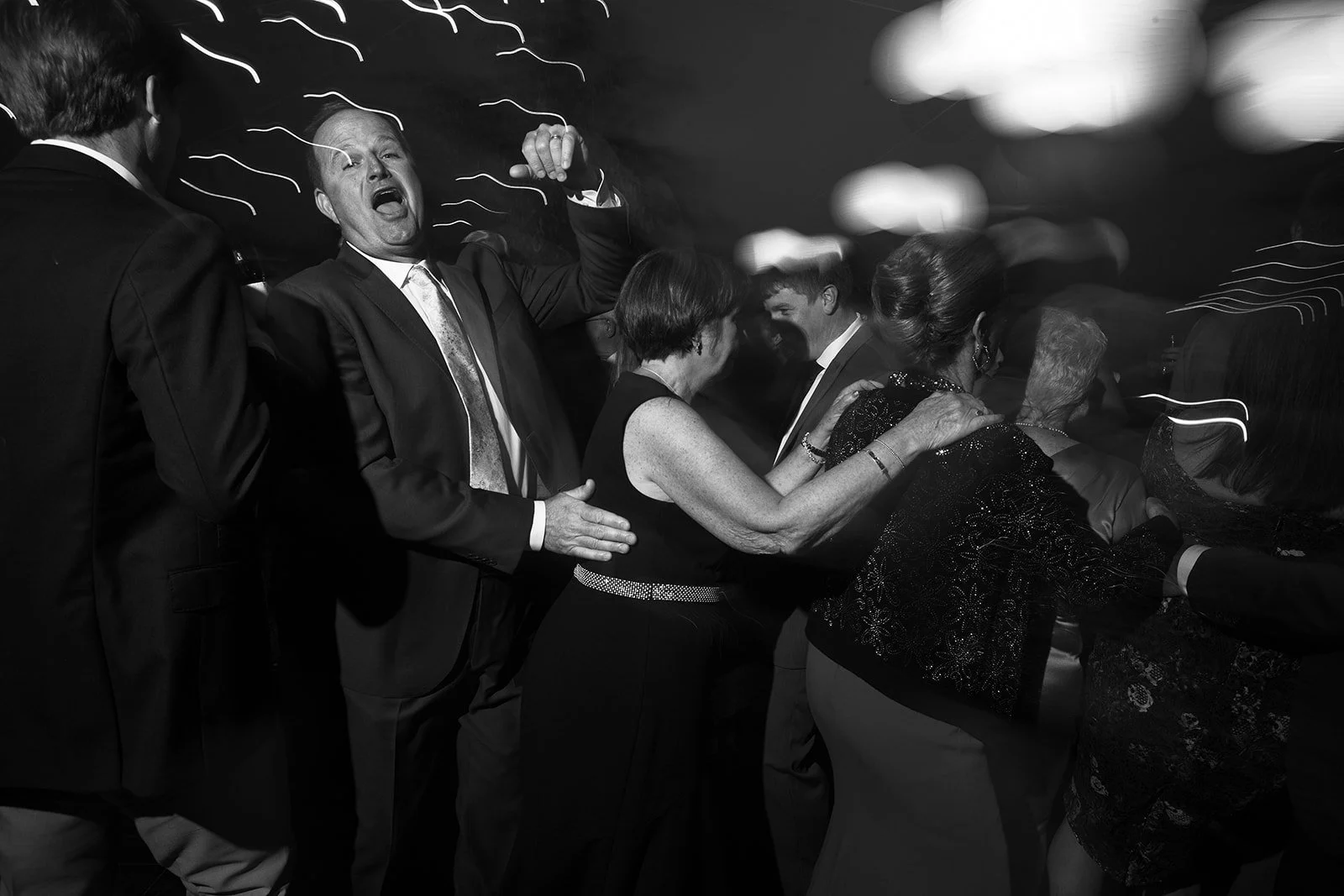 People dancing at a celebration or party in a black and white photo.