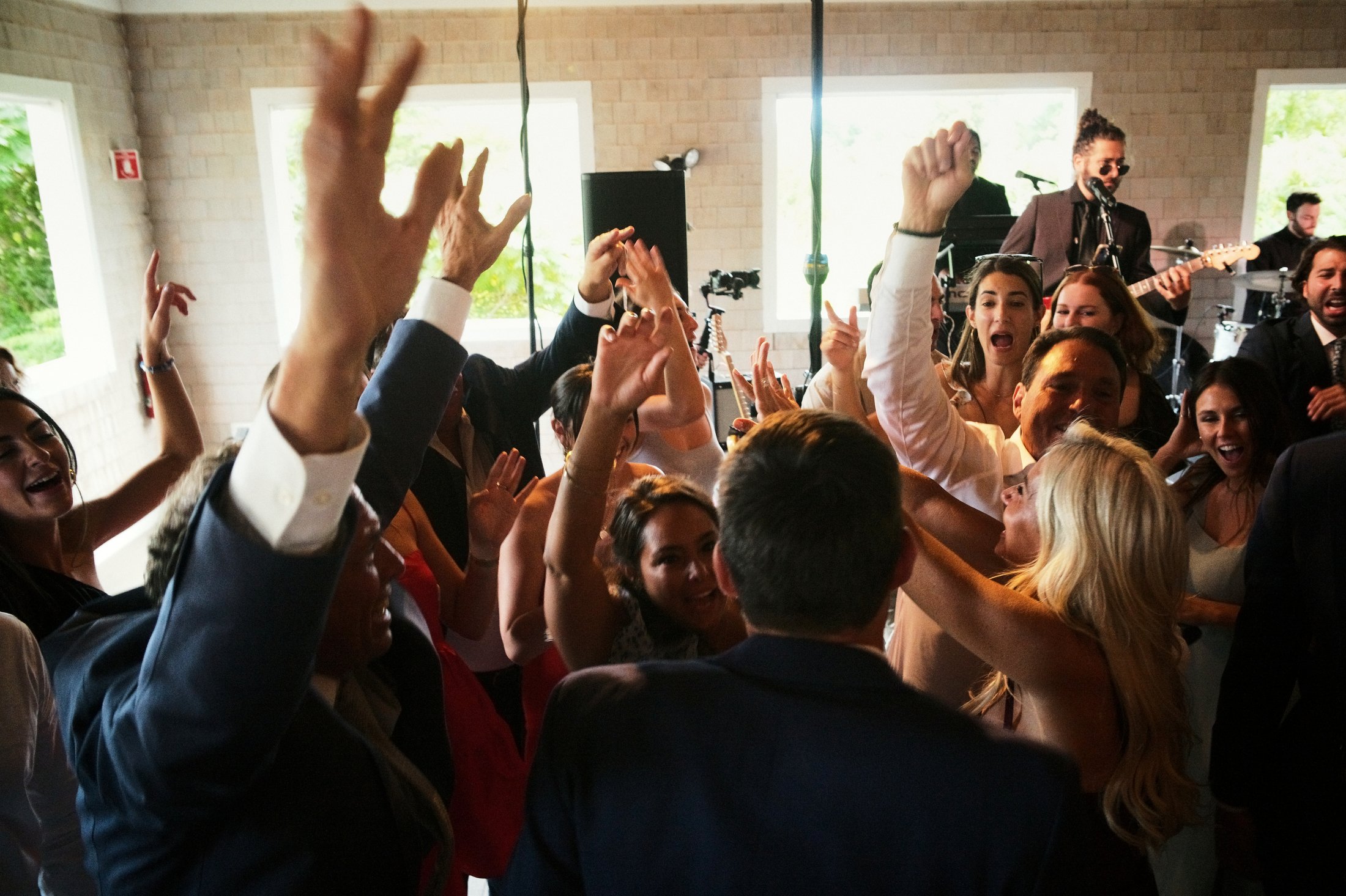 People dancing and celebrating at a party with a live band playing in the background.