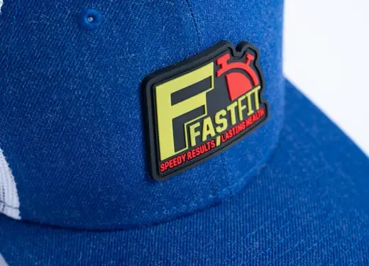 Close-up of a blue cap with a rectangular logo tag that reads 'Fast F' in large letters and 'Speedy results, lasting heals' underneath.