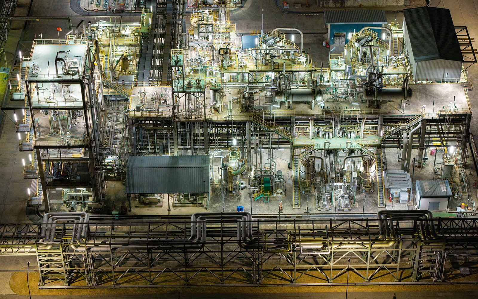 Aerial view of a large scale industrial refinery facility at night with interconnected processing systems