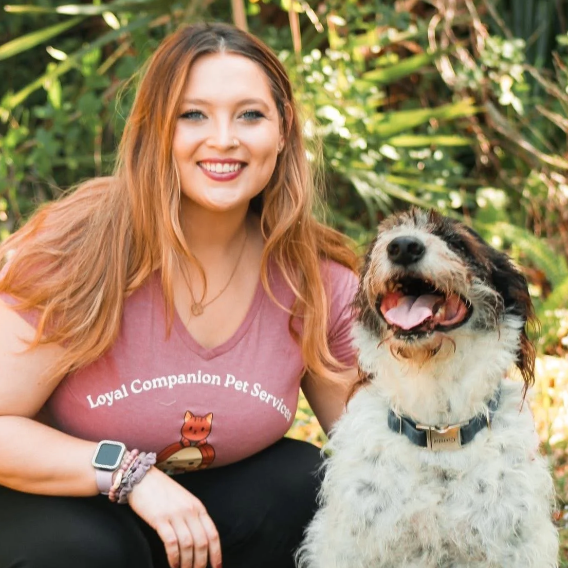 Woman smiling next to a happy dog