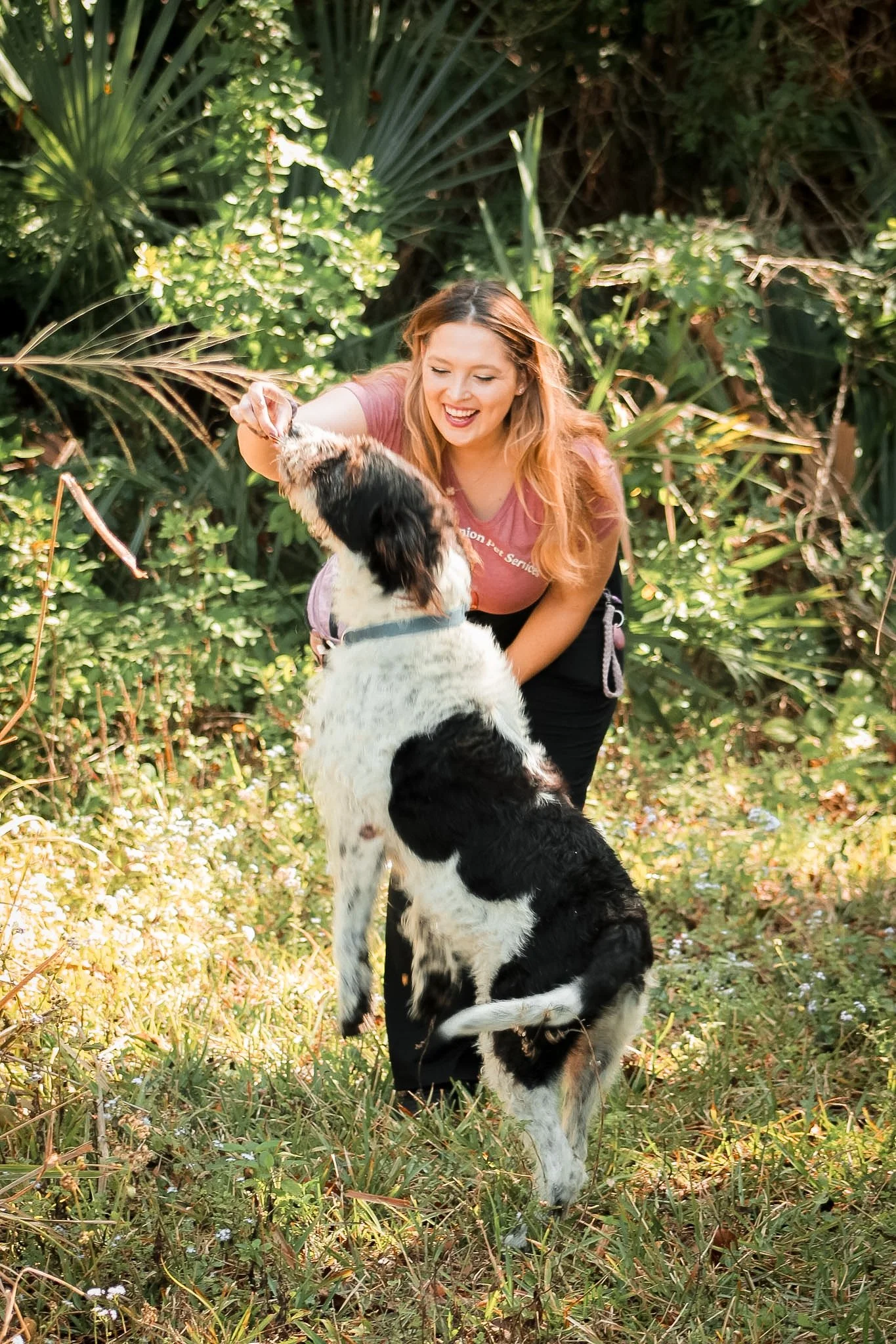 Woman pet sitter feeding dog treats outside in Florida