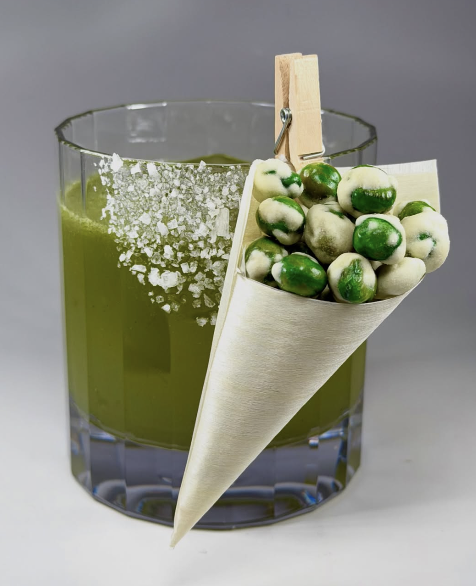 Innovative zero-proof green cocktail with a salt rim and a unique wasabi pea garnish cone, designed by Dry Mixology Arabia for creative event beverage experiences in the UAE.