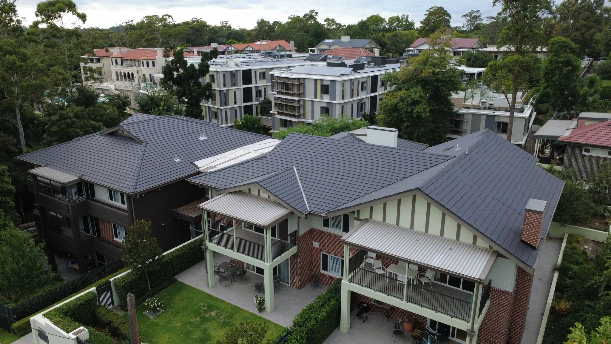 Modern dark tile roof installation on luxury residential home