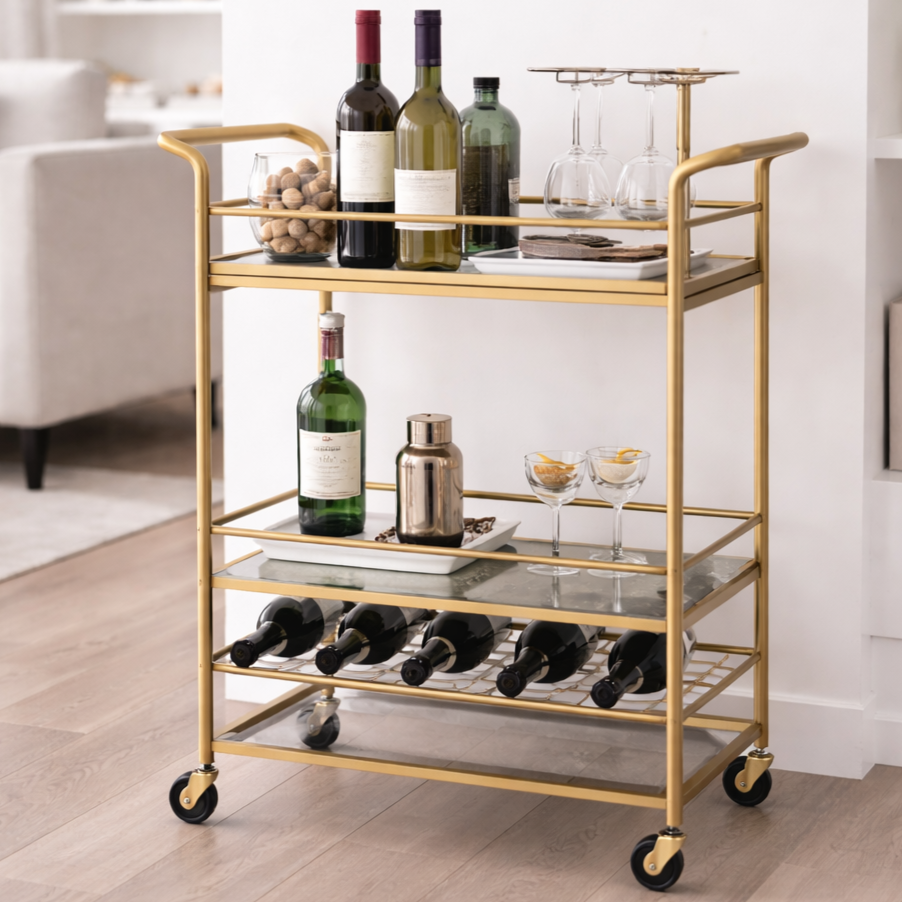 Stylish modern gold bar cart with wine bottles, glassware, and a few accessories in a modern home setting