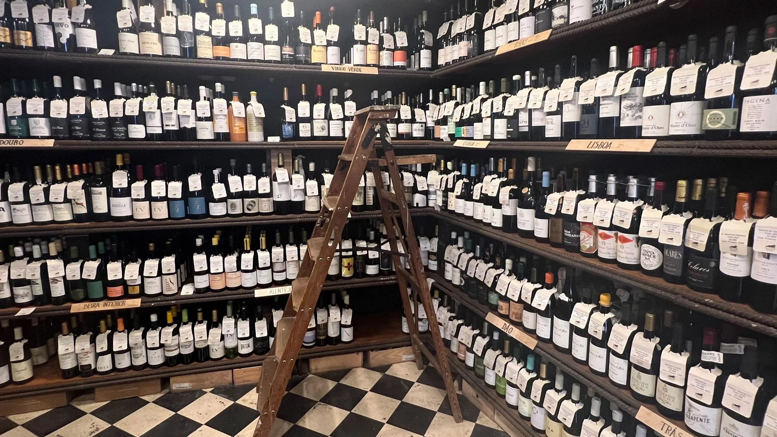 Wine bottles displayed upright on shelves inside a wine shop
