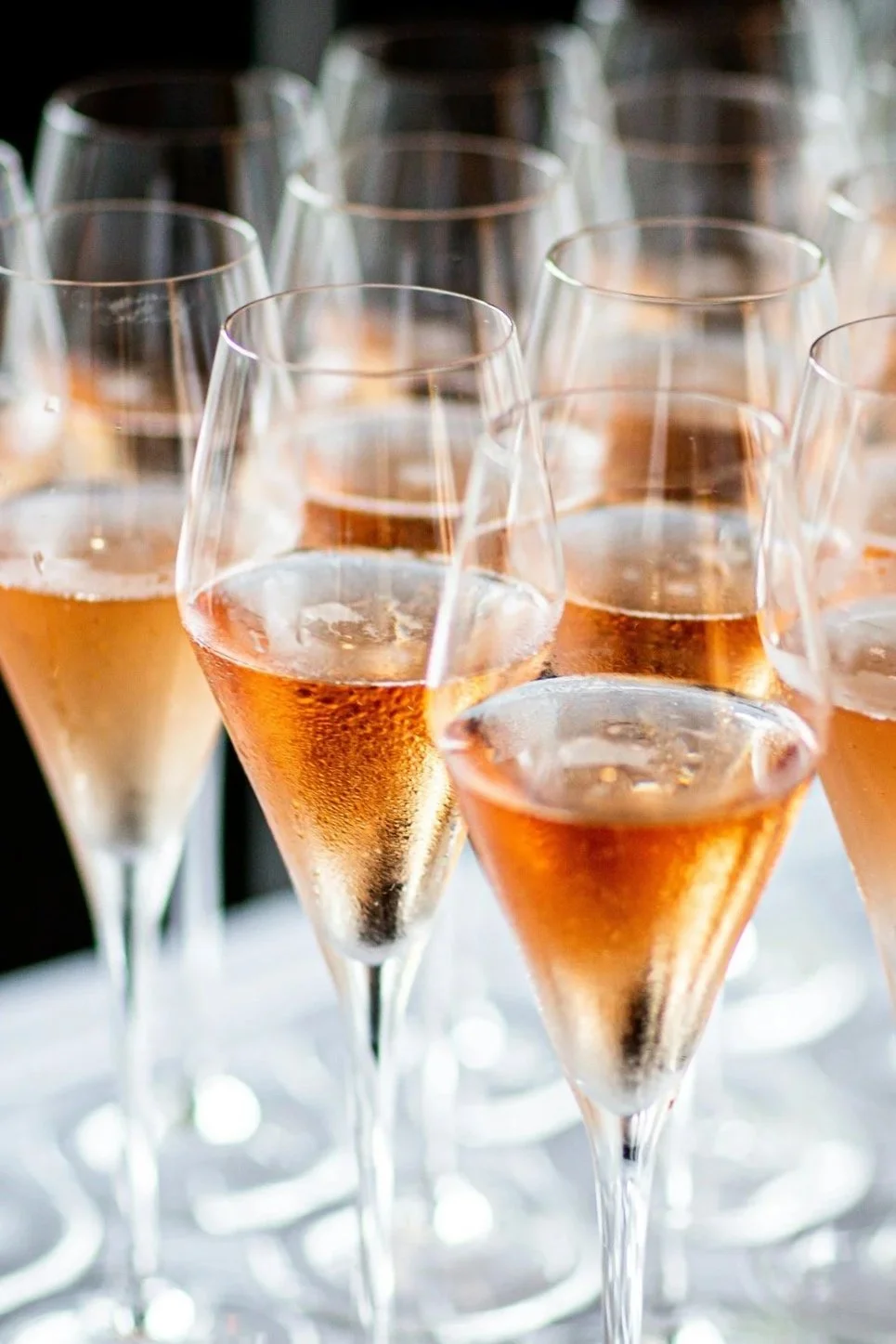 Group of tulip shaped Champagne glasses filled with Brut Rose Champagne.