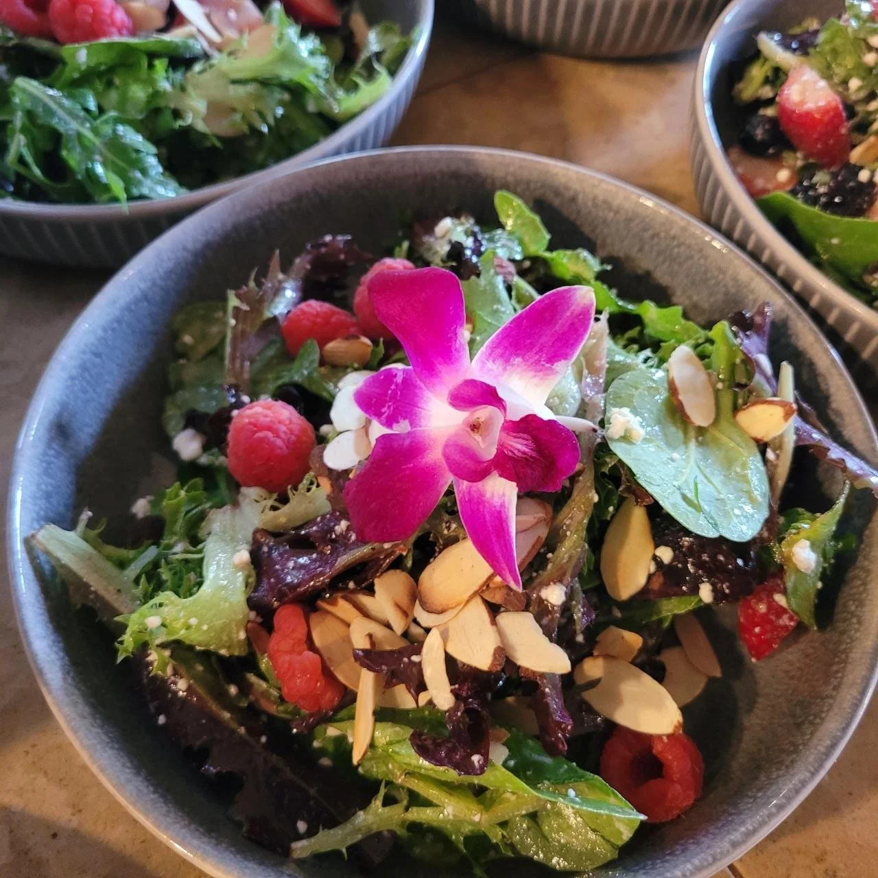 Fresh spring salad with berries and an edible flower made for a private dinner event