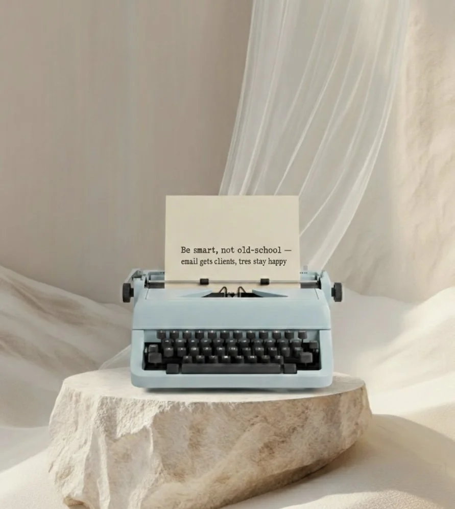 A blue typewriter on a stone slab with a note inside that reads 'Be smart, not old-school — email gets clients, trees stay happy.'