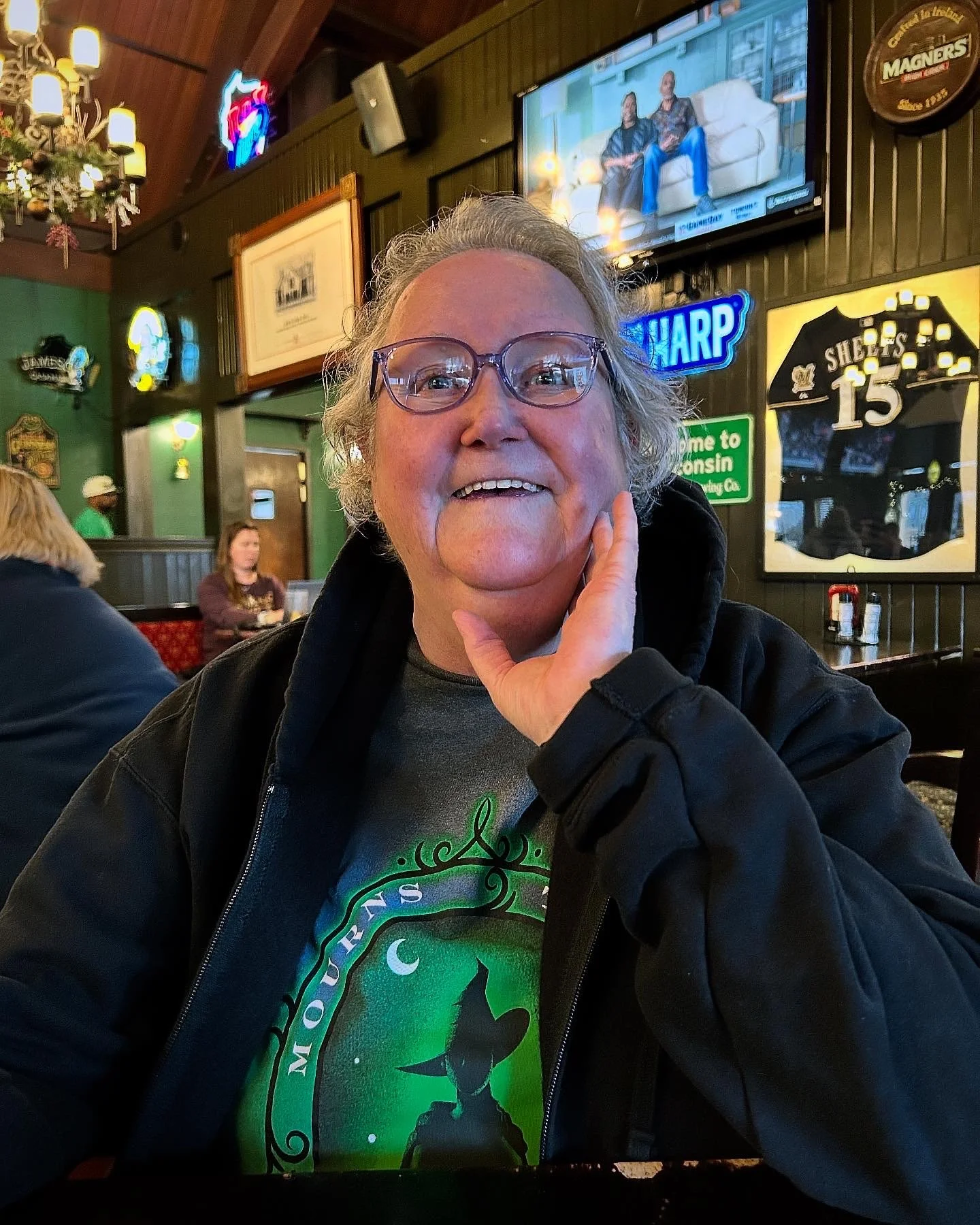 Photo of the author's mother, Laurie, smiling brightly and cupping her face with one hand.