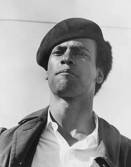 Portrait of Huey P. Newton in a Black Panther beret, representing revolutionary Black intellectualism.