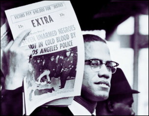 Malcolm X holding up a news bulletin headlined: ‘Seven Unarmed Negroes Shot in Cold Blood by Los Angeles Police.’
