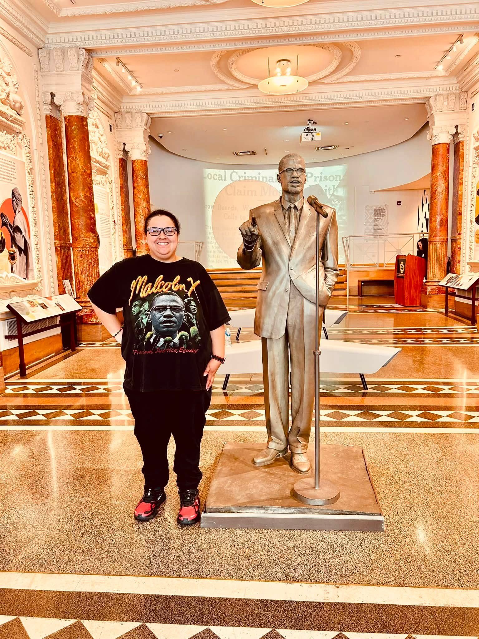 Holly Burgess wearing a Malcolm X t-shirt inside of the Shabazz Center where Malcolm was assassinated.