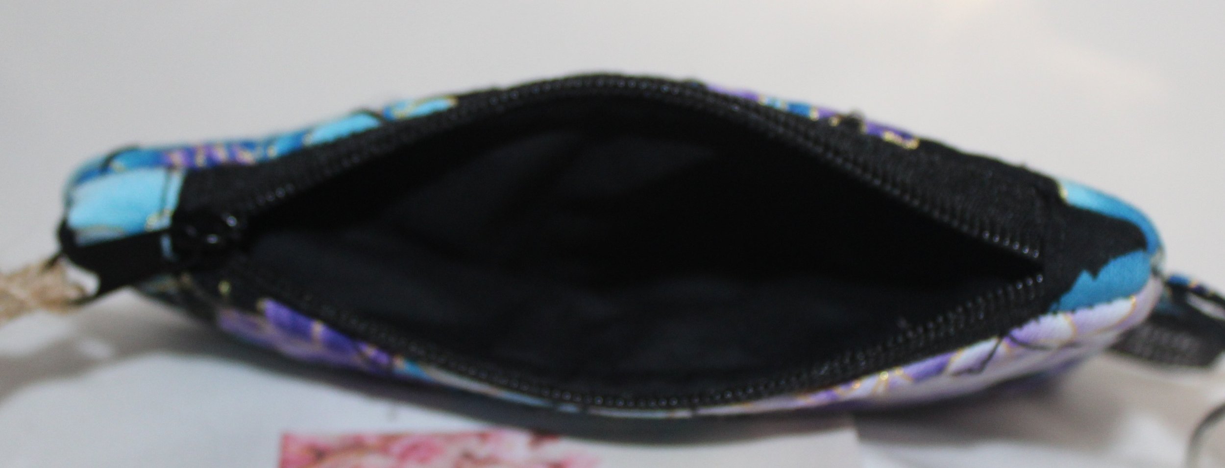 Top view of quilted keychain wallet with twilight paisley pattern, zipper closure, and metal key ring.