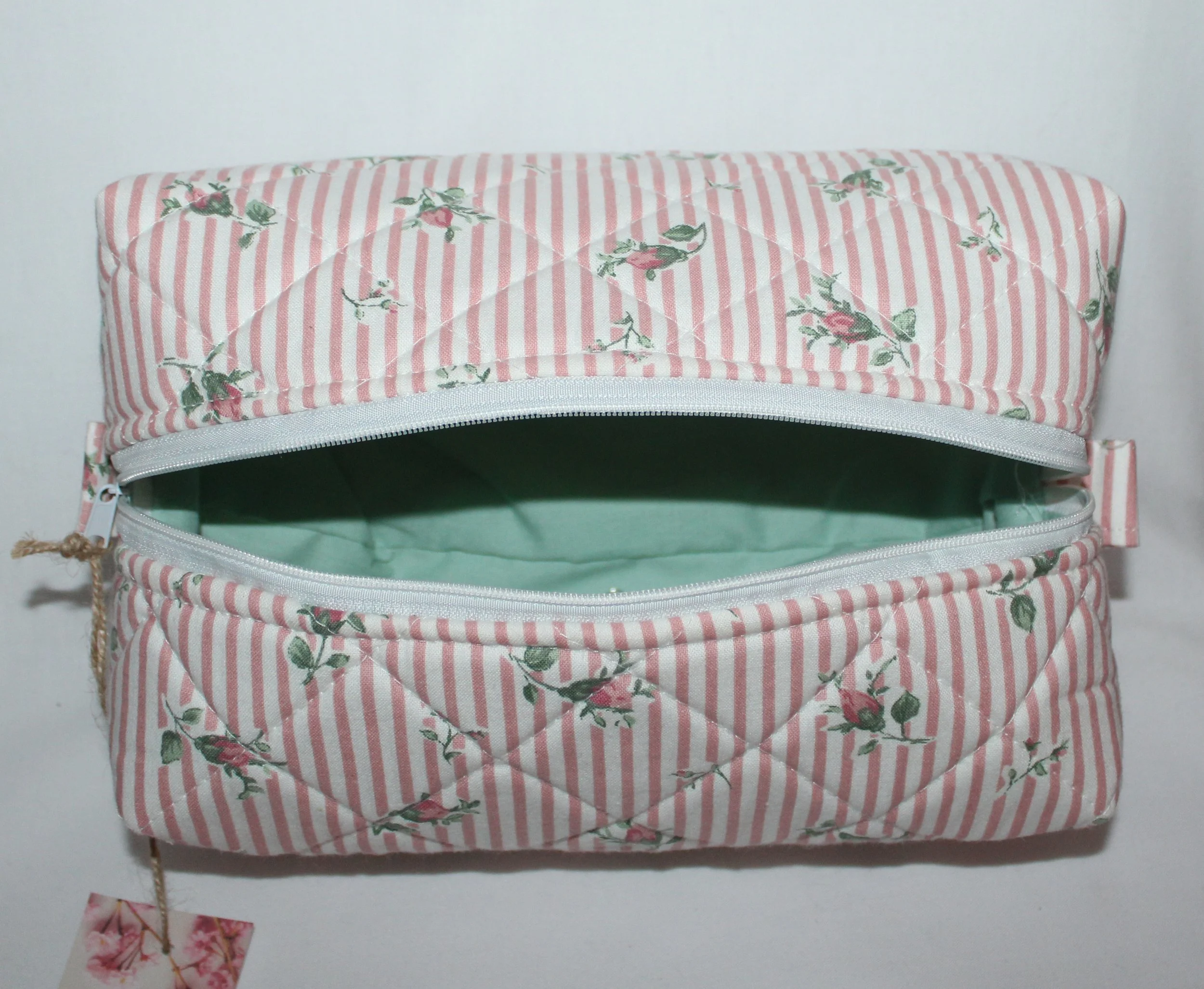 Top view of the Victoria quilted travel pouch, shown the empty mint green lining.