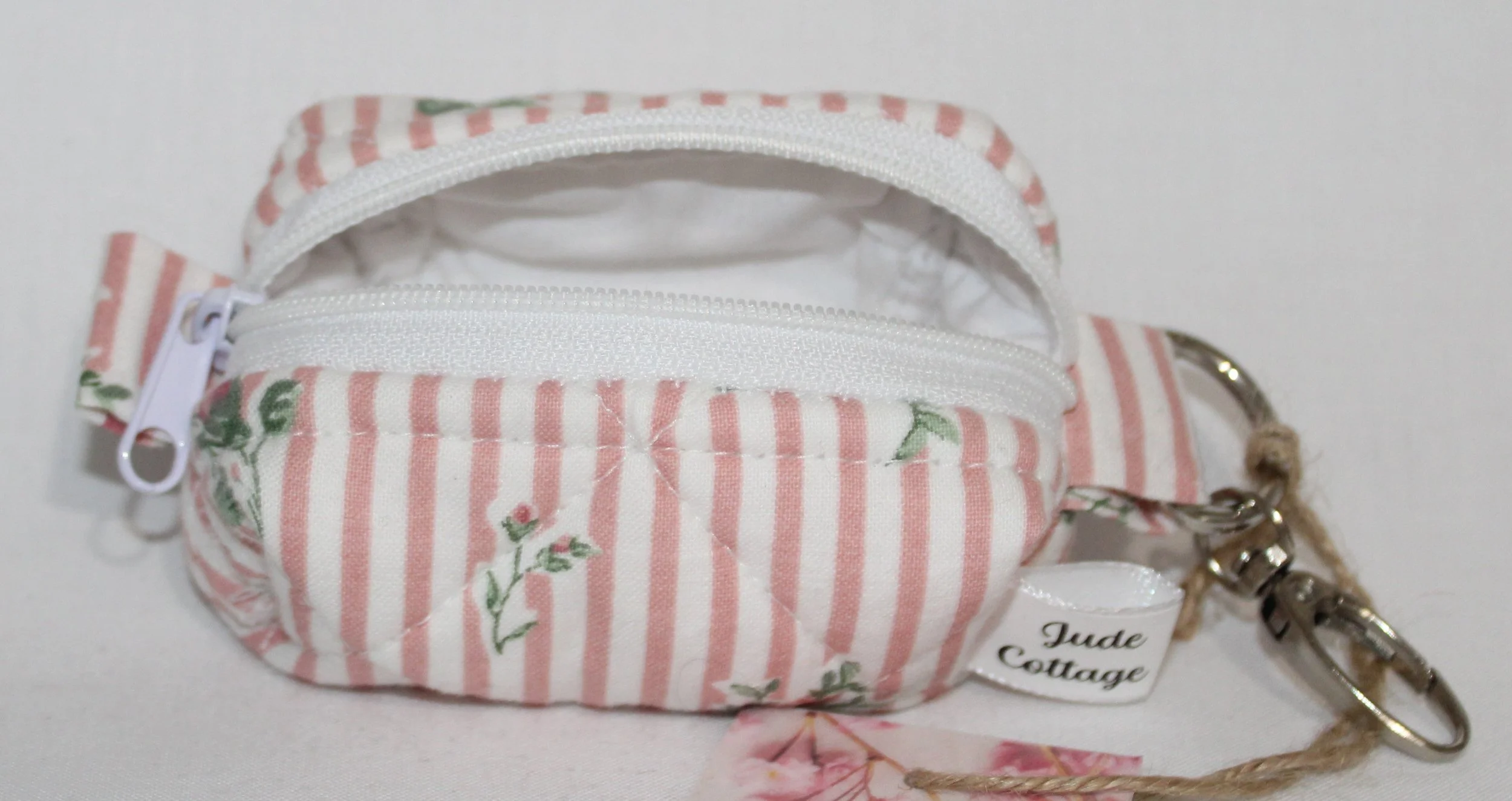 Empty open top view of the Victoria bag charm featuring pink and white stripes with pink rose bud printed fabric showing white lining fabric.