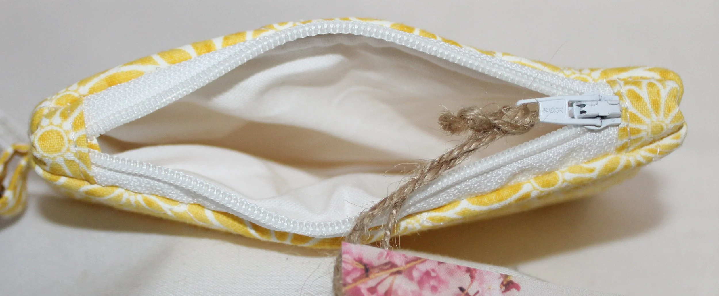 Top view quilted keychain wallet with golden daisy pattern, zipper closure, and metal key ring.