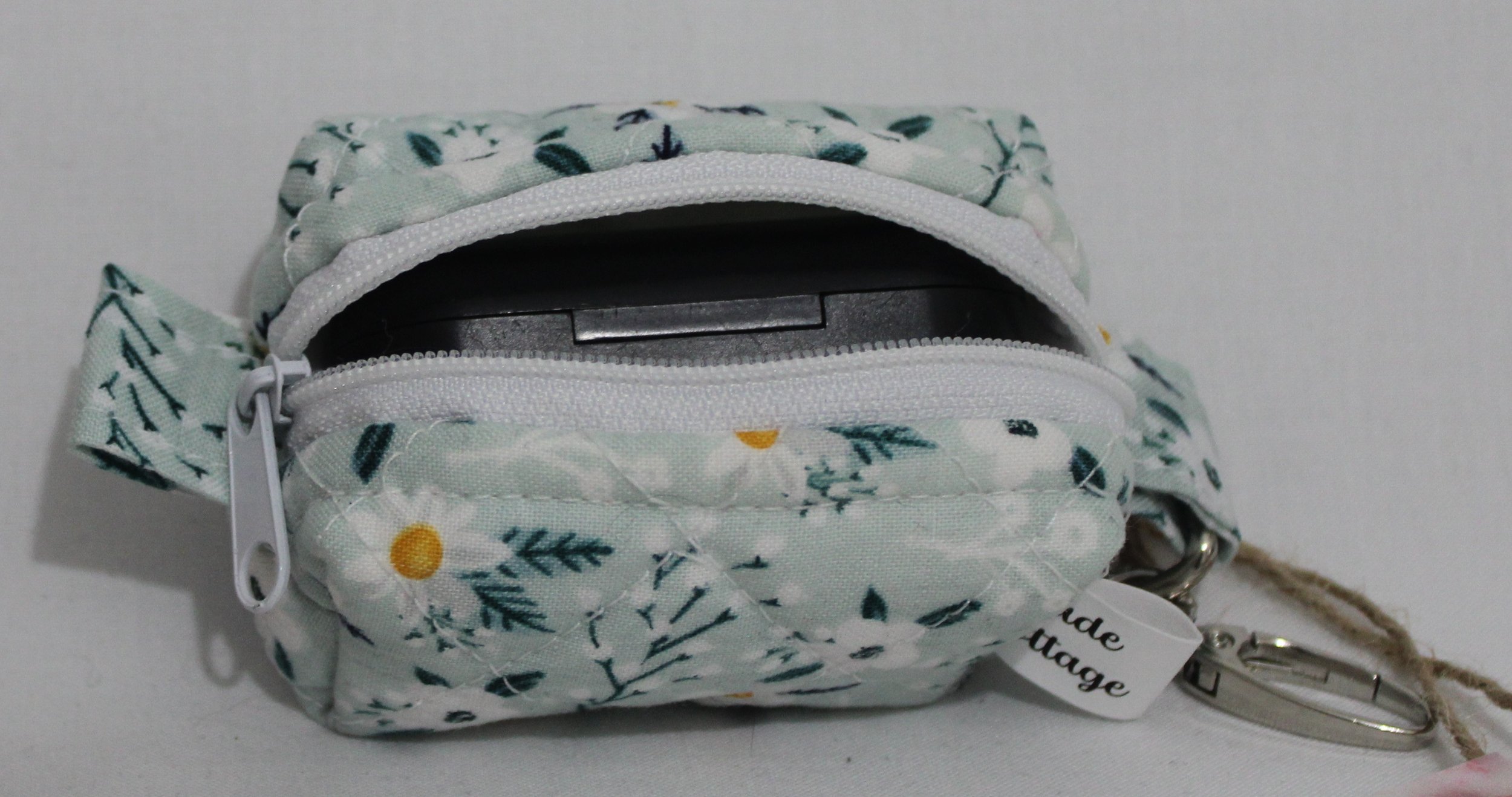 Top open view of the Vera Bag Charm shown with a J Lab earbud case inserted for demonstration of sizing.