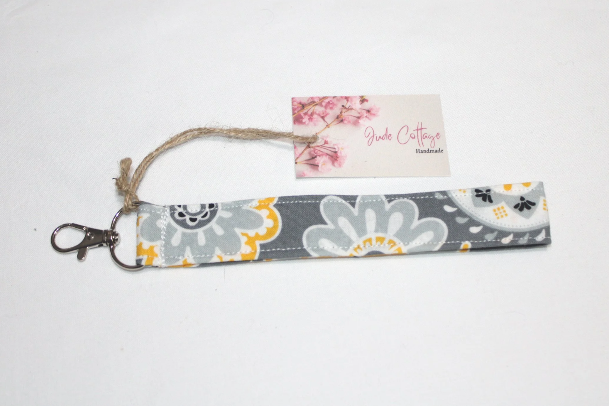 Closeup of the Medallion wristlet showing the grey, white, black, and gold floral pattern.