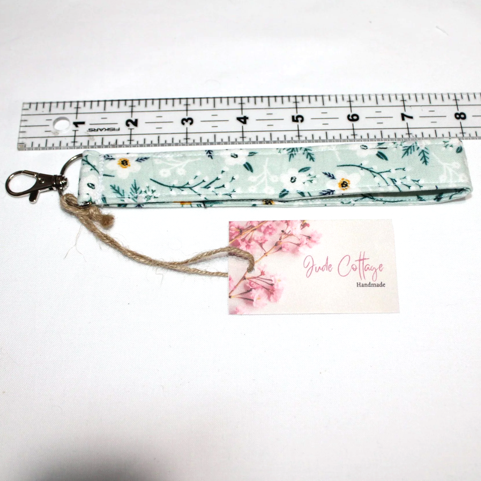 Close-up view of Vera wristlet shown below a ruler to illustrate the length and a view of the lobster clasp..