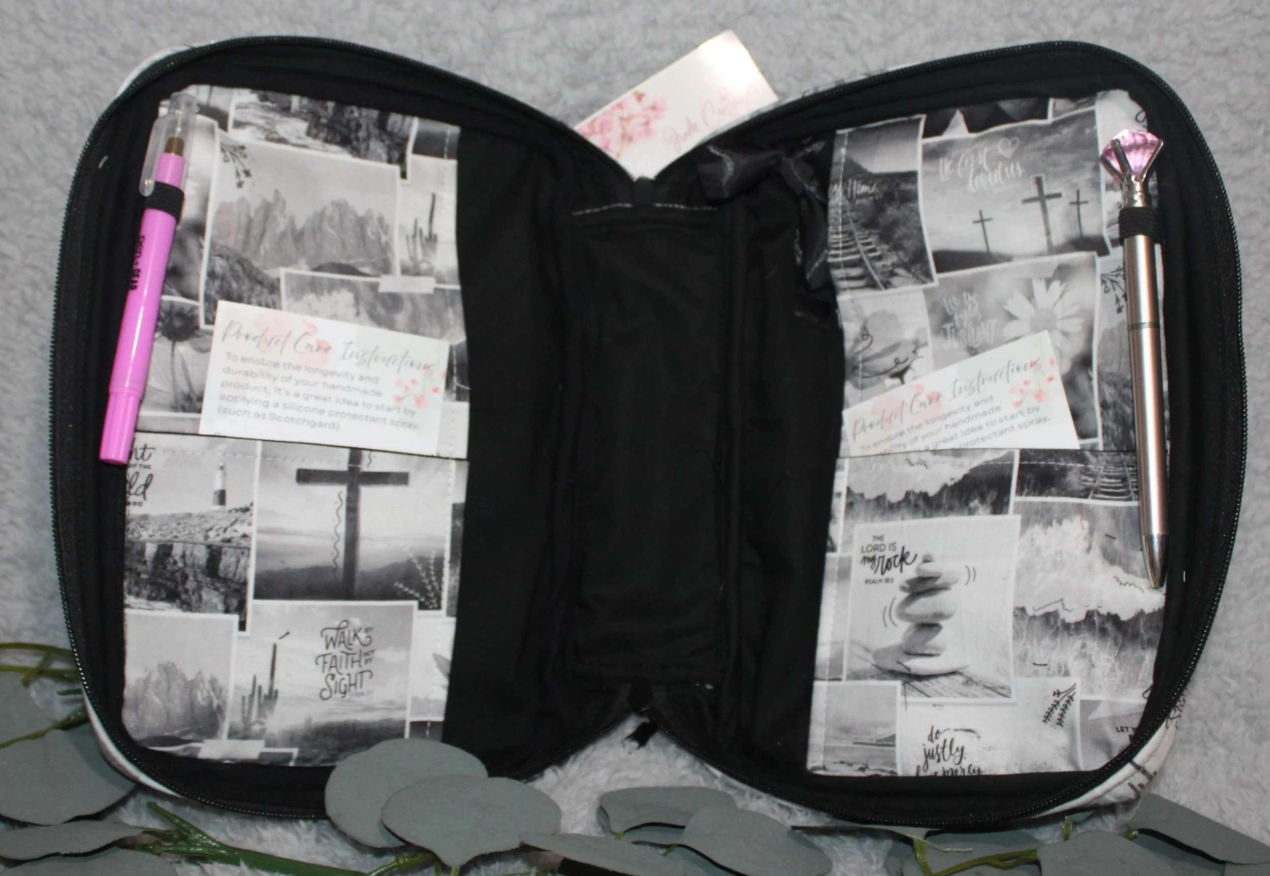 Interior of the Calvary Study Bible Case featuring monochrome inspirational text, black lining, two pens, and product‑care cards in the pockets.