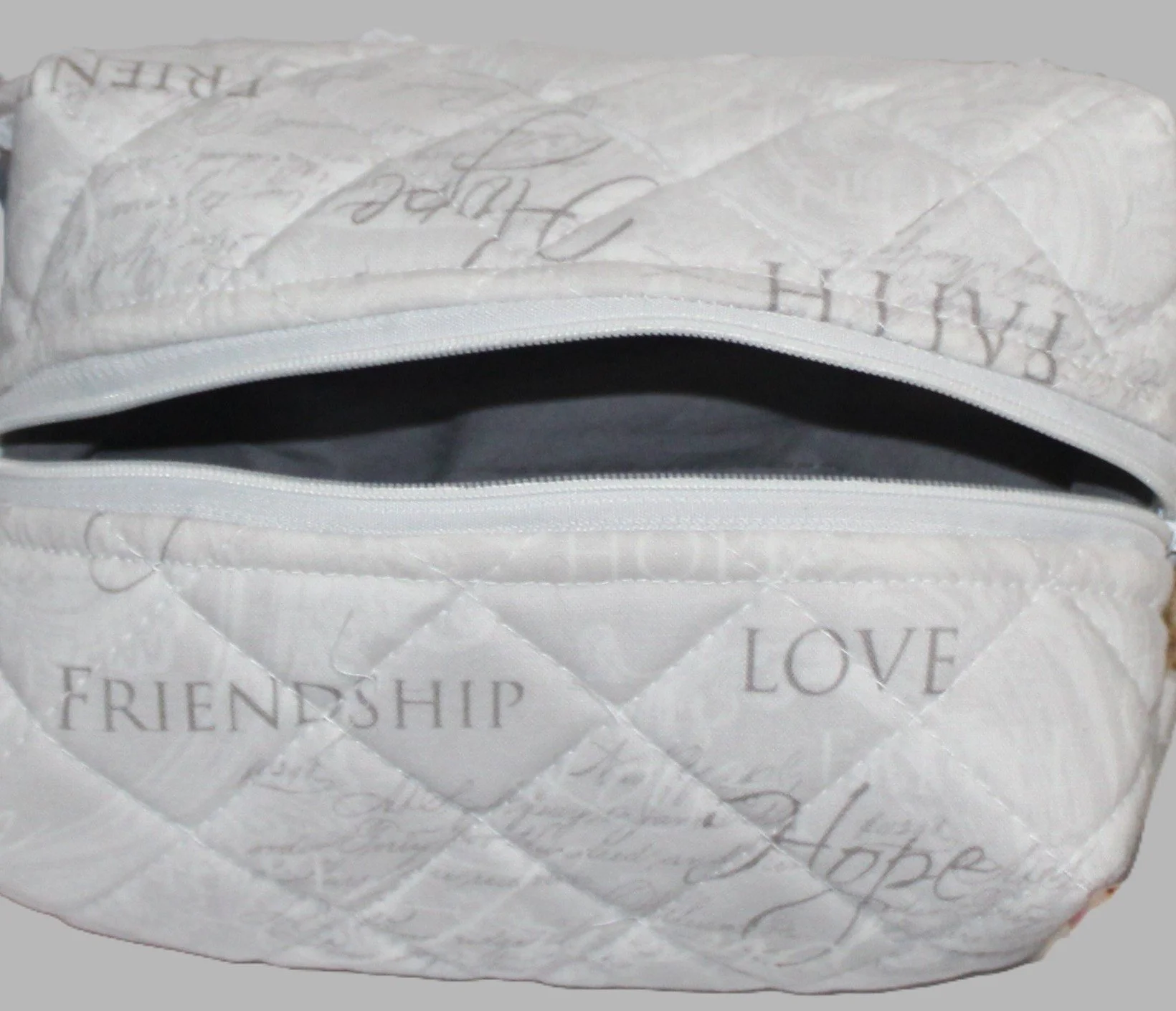 Top view of the Faith Hope Love quilted tote with the white zipper open, showing the grey lining.