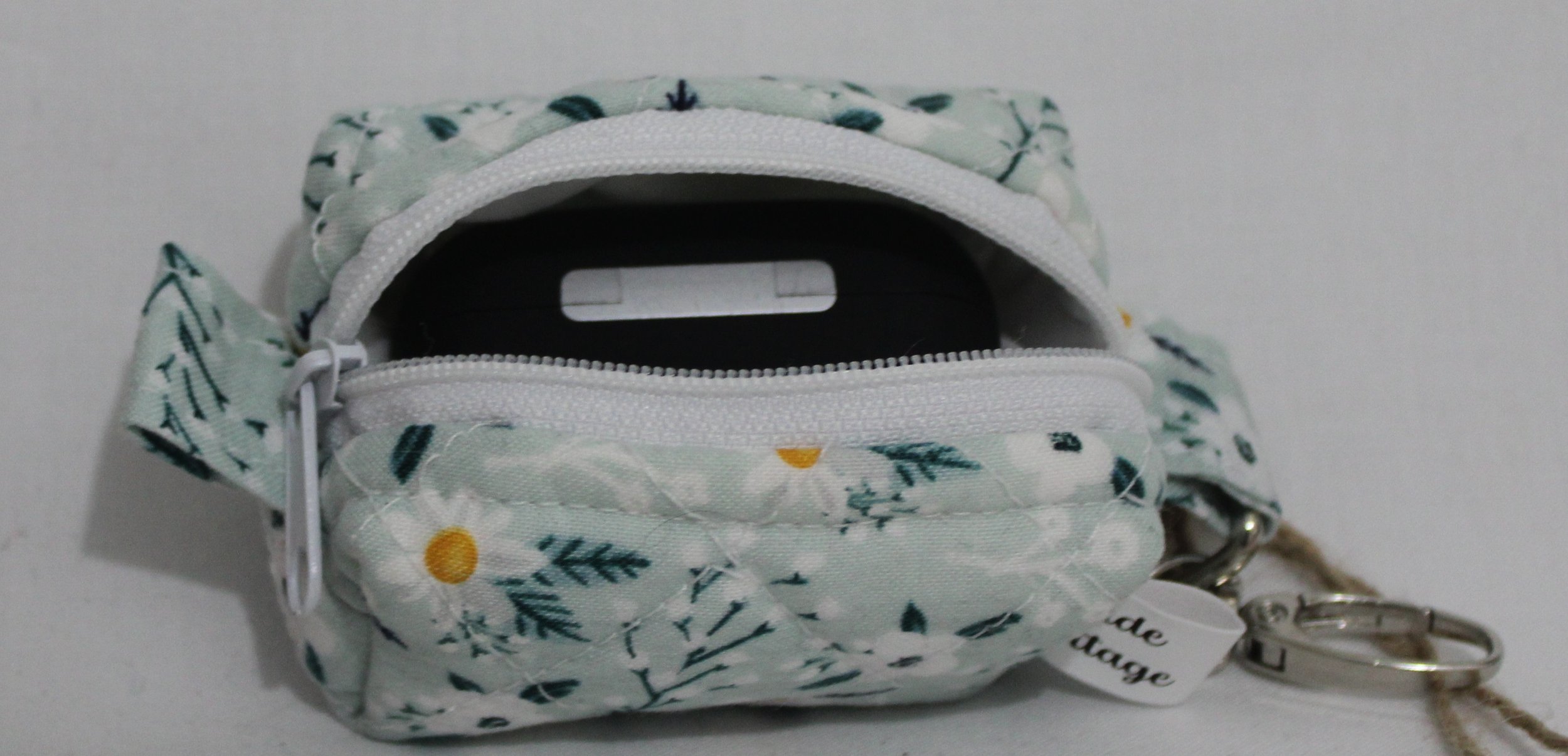 Top open view of the Vera Bag Charm shown with an Airpod Pro case inserted for demonstration of sizing.