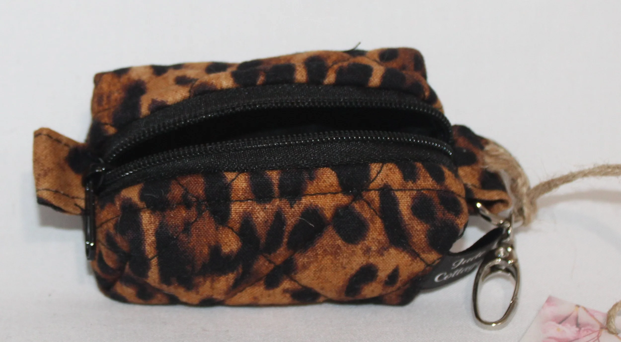 Top open view of the Lyra Bag Charm featuring a leopard print fabric and showing black zip enclosure and lining.