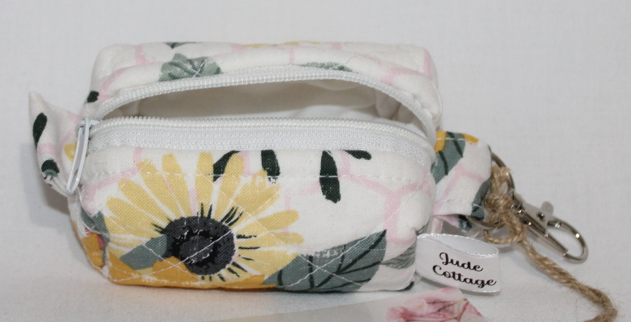 Open top view of the Honeycomb Sunflower Bag Charm featuring a white fabric with pink honeycombs and yellow sunflower print showing white zip closure and lining.