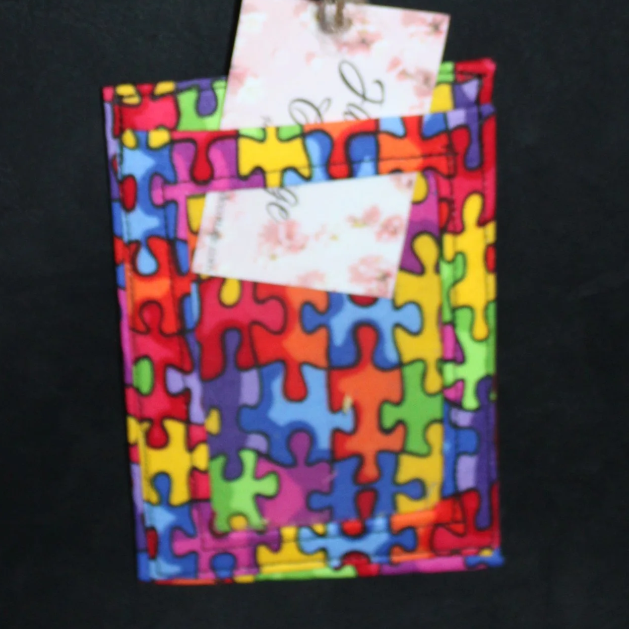 Front up close view of the Autism Badge holder shown with card partially inserted to show clear ID slot.