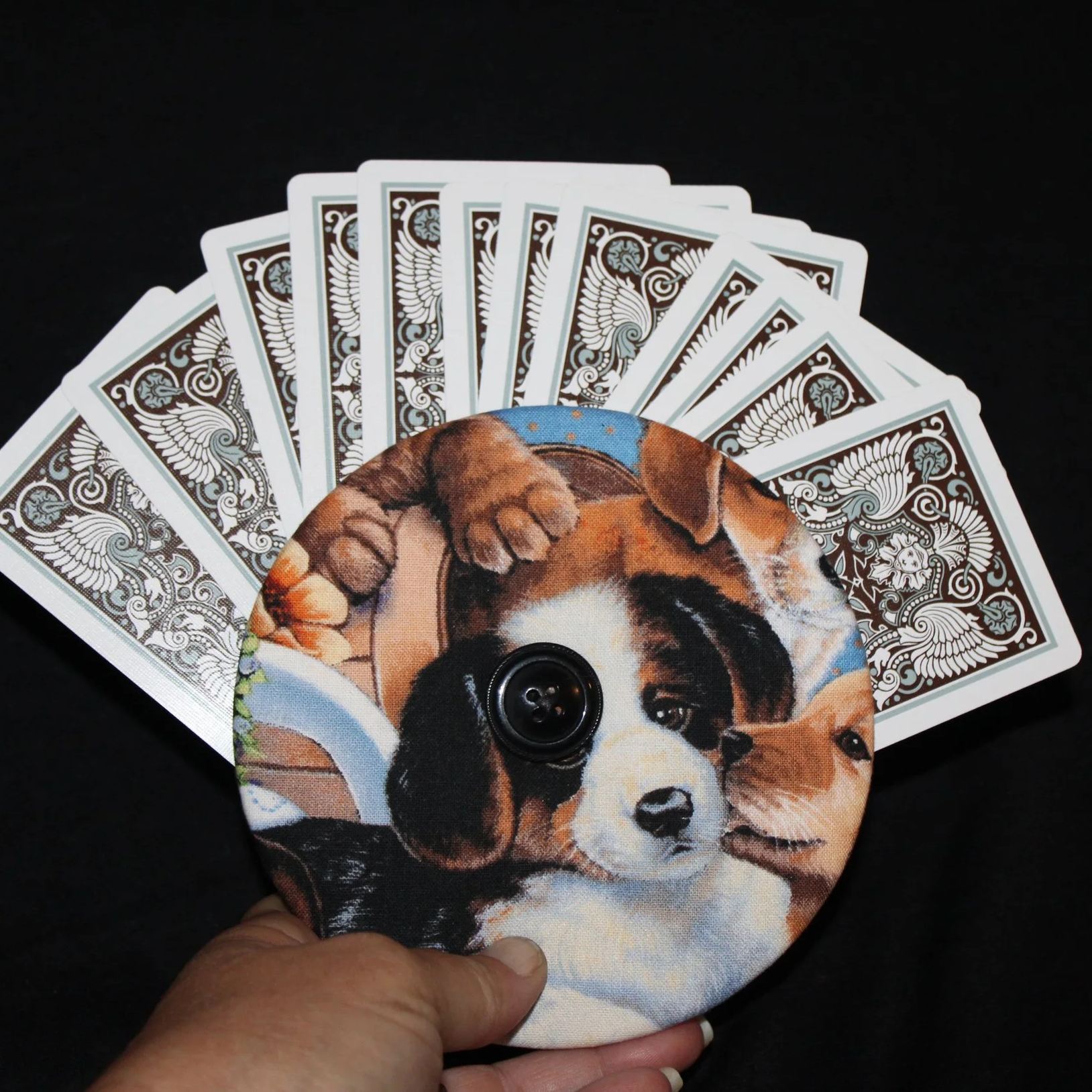 Front view of the Puppy Love Card holder featuring an assortment of dog breeds shown in use being held with an array of playing cards.