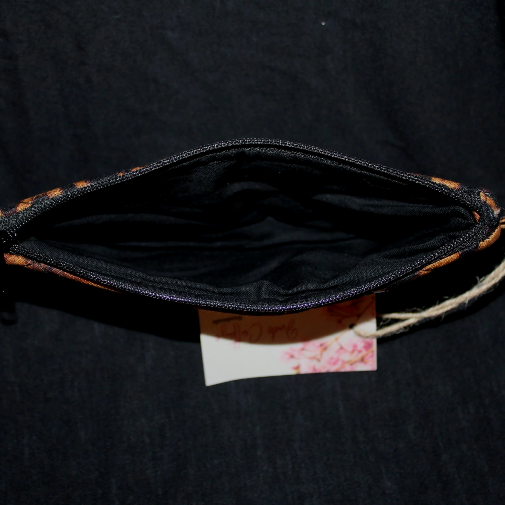 Top open view of the Lyra Large Keychain Wallet showing the black zip enclosure and lining.