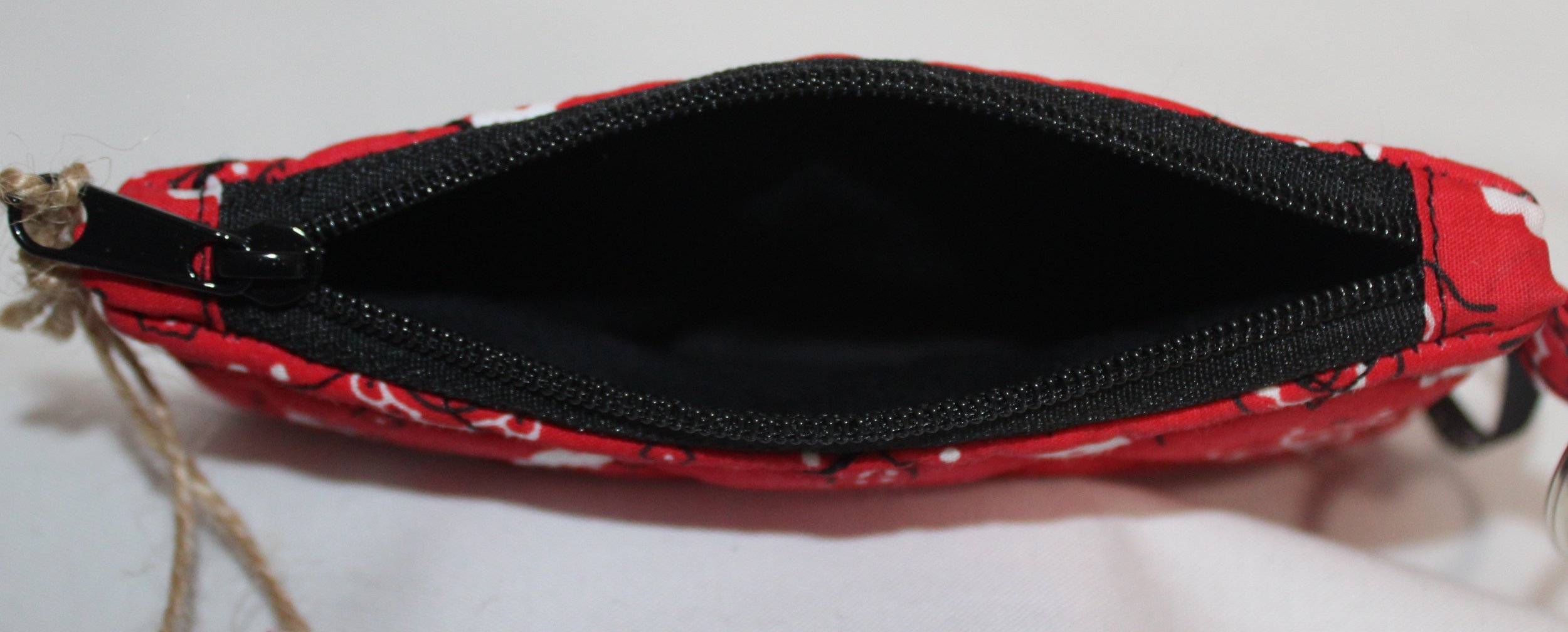 Top view of red quilted keychain wallet with patriotic pattern, zipper closure, and metal key ring.