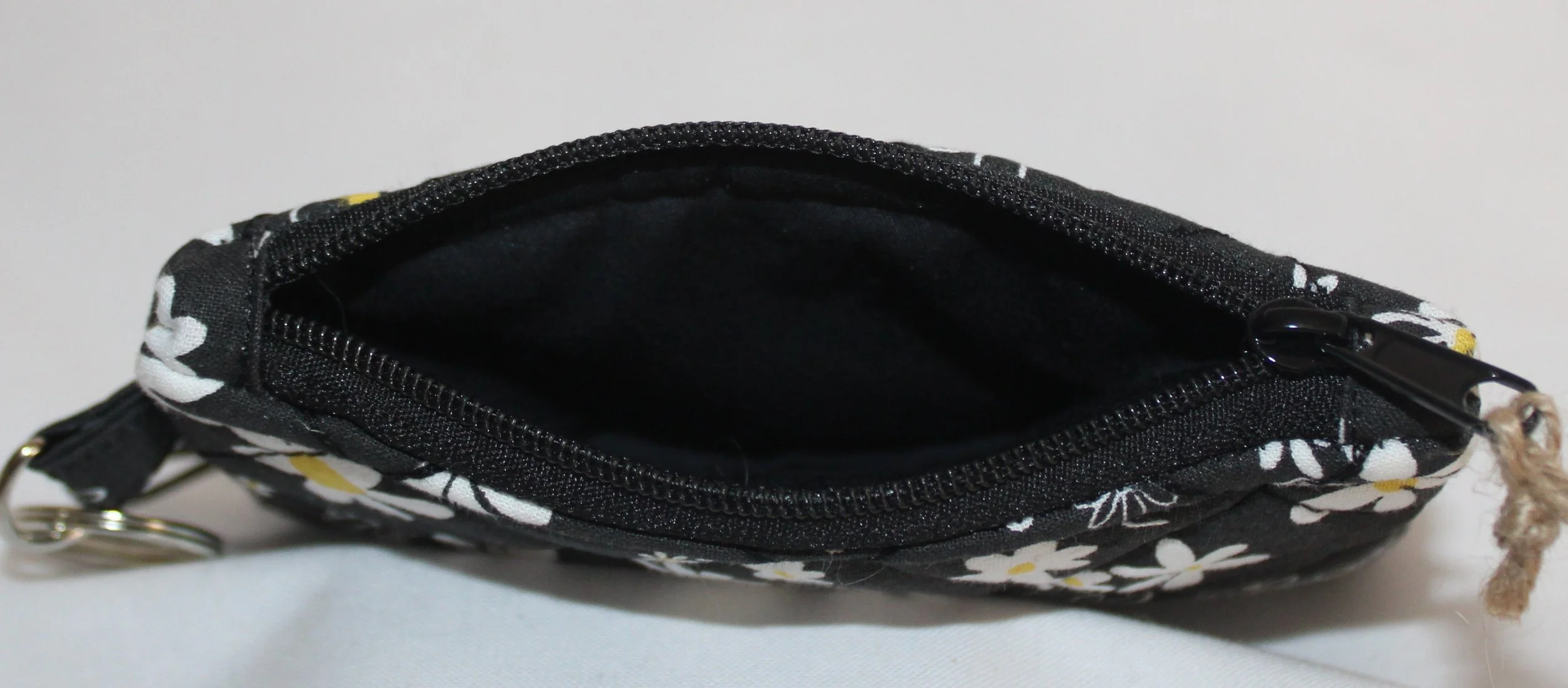 Top view of floral wallet showing the zipper and black interior.