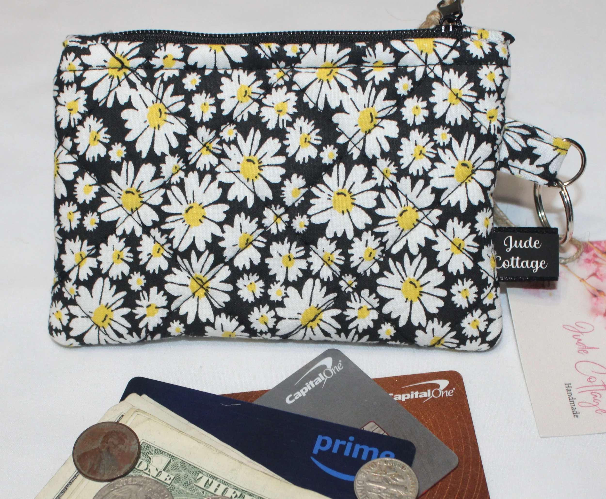 Quilted keychain wallet with small daisy pattern, zipper closure, and metal key ring.
