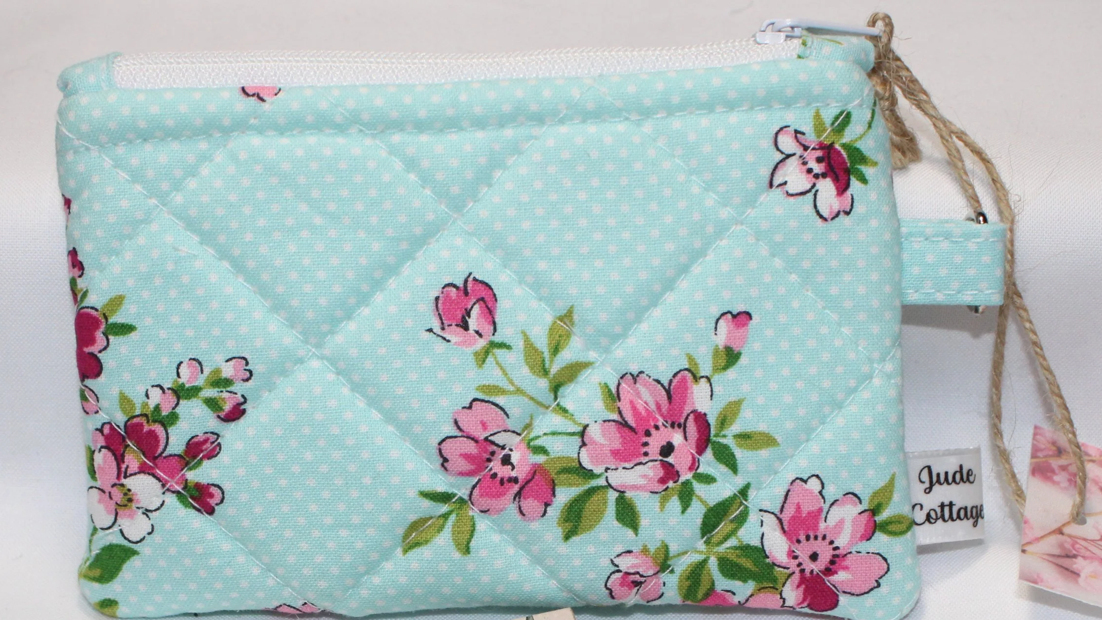 Quilted cherry blossom keychain wallet with blue background pattern, zipper closure, and metal key ring.