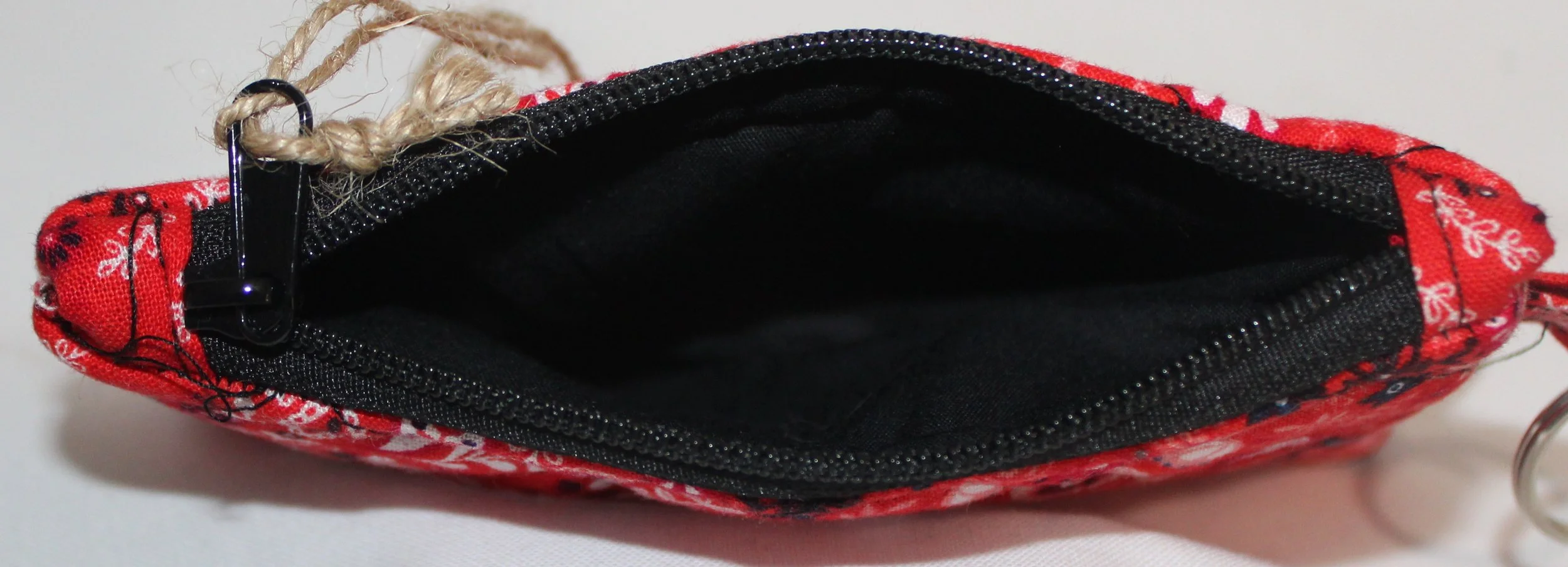 Top view of red bandana-pattern quilted keychain wallet with zipper closure and metal key ring.