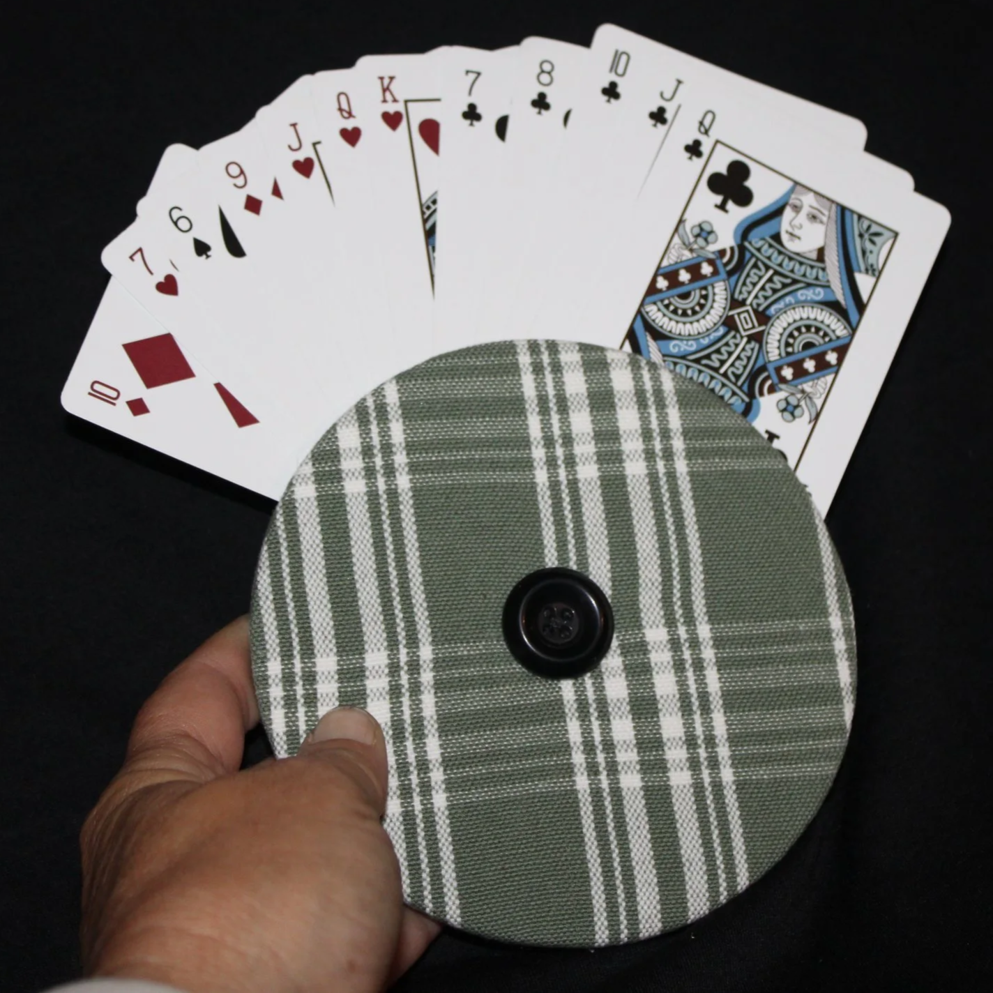 Front view of the Sage Plaid Card Holder featuring a dark sage and white plaid print shown in use being held with an array of playing cards.
