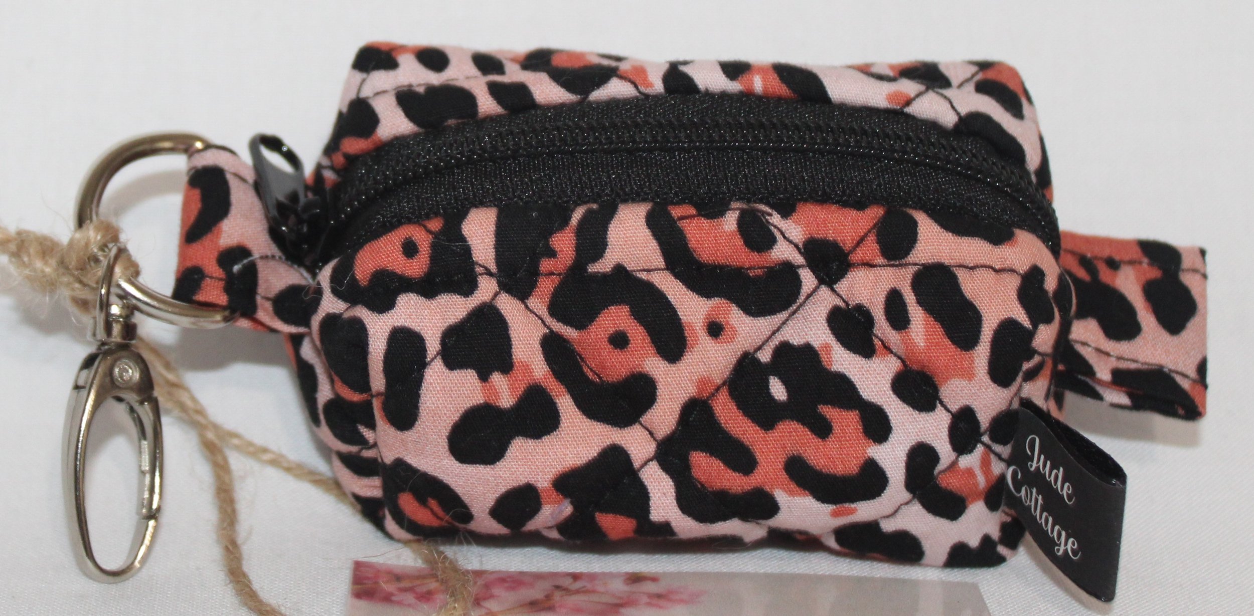 Top view of the Mia Bag Charm featuring pink leopard print fabric showing black zip enclosure.