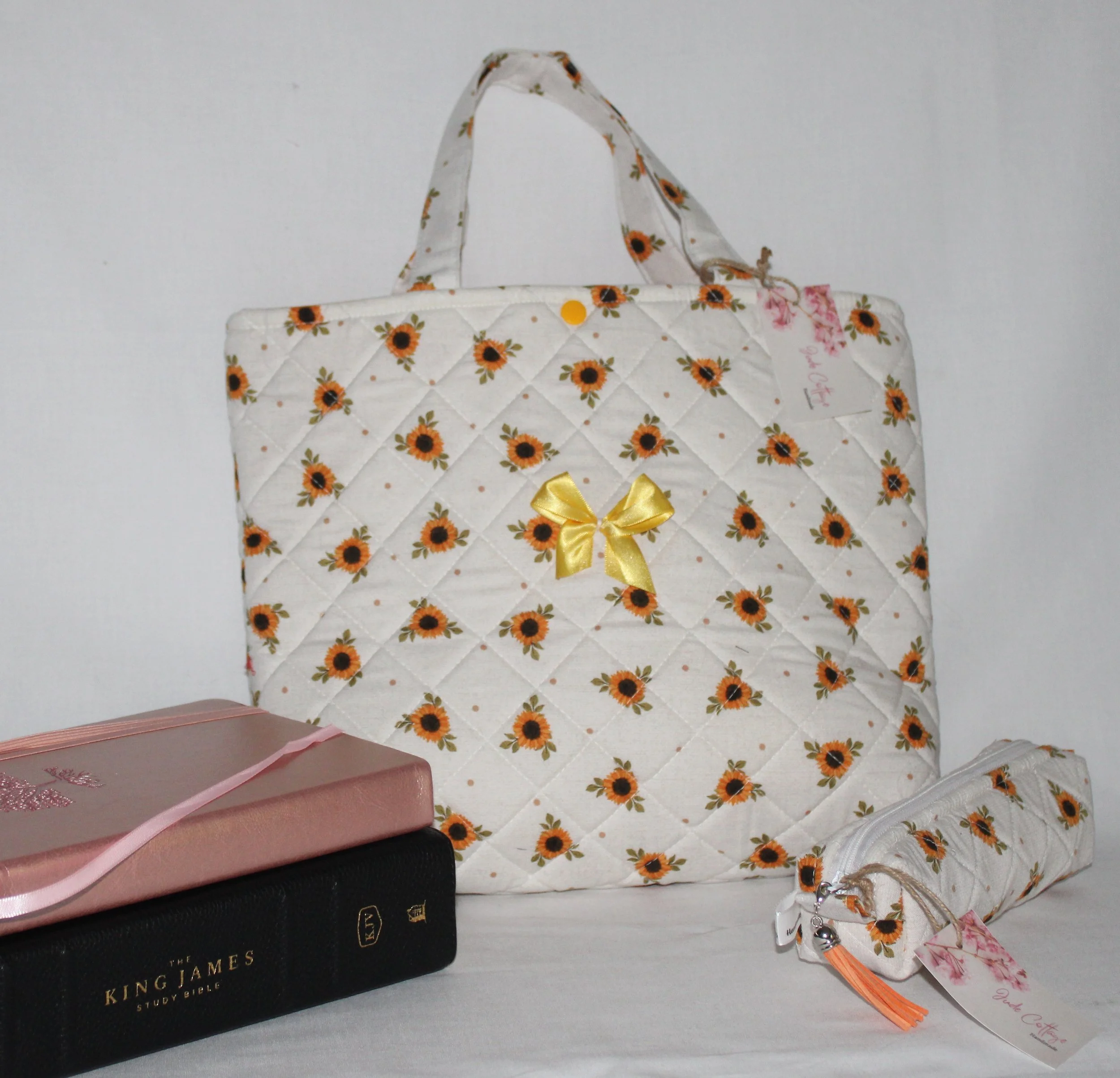 Sunflower Medley quilted Bible sleeve, featuring dainty sunflowers on a cream background, shown with a study Bible and notebook to illustrate size and intended use.