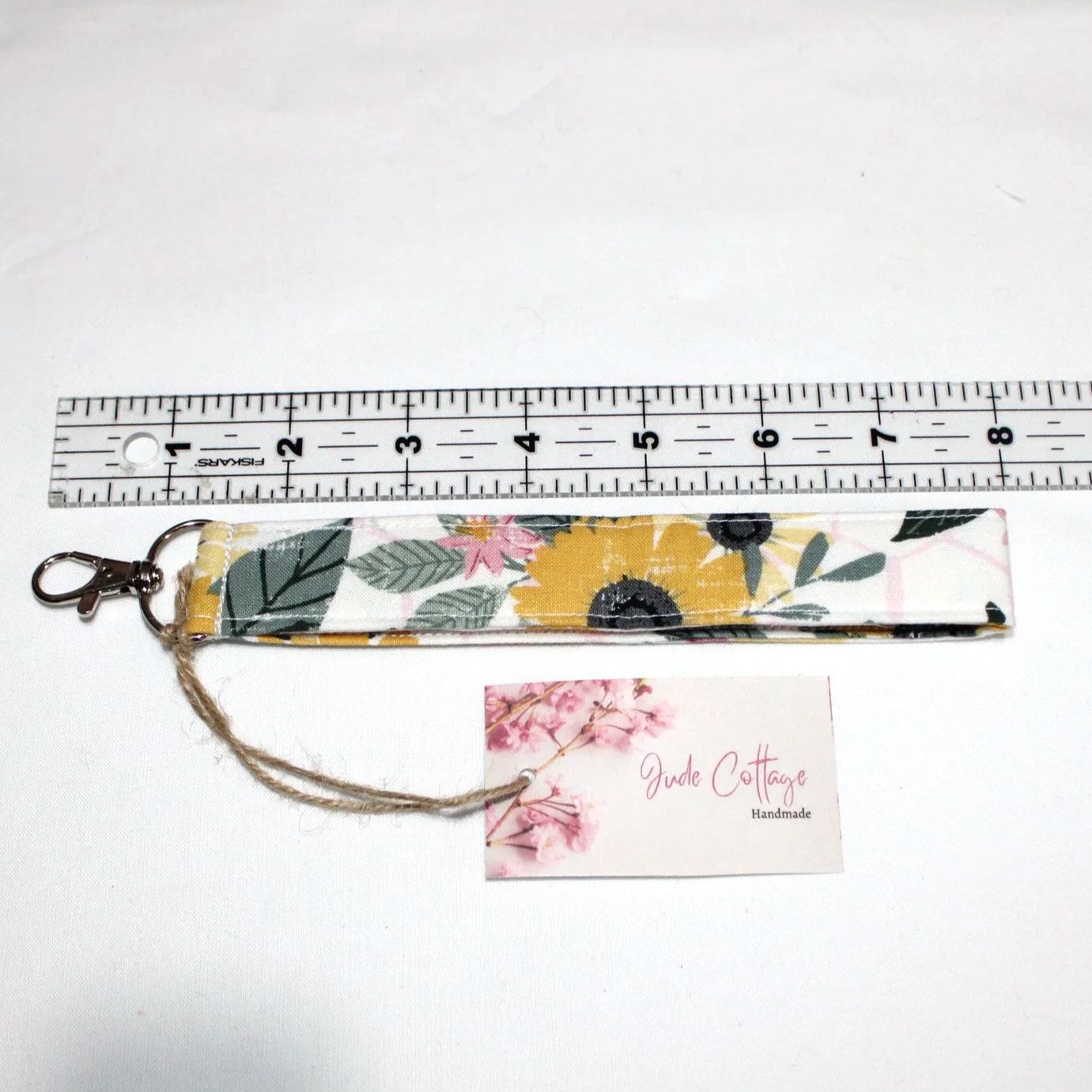 Honeycomb Sunflower Wristlet shown below a ruler to demonstrate length and featuring a light pink honeycomb design on white background with Sunflowers.