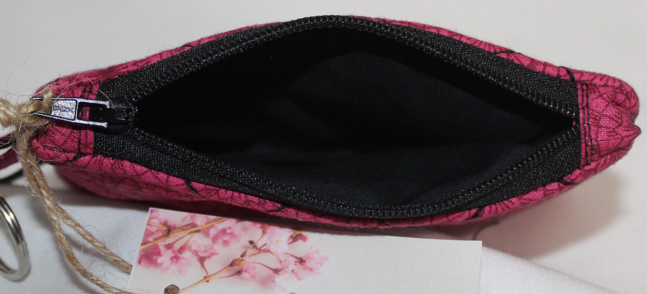 Top view of Claire quilted fuchsia keychain wallet featuring zipper closure and black lining.