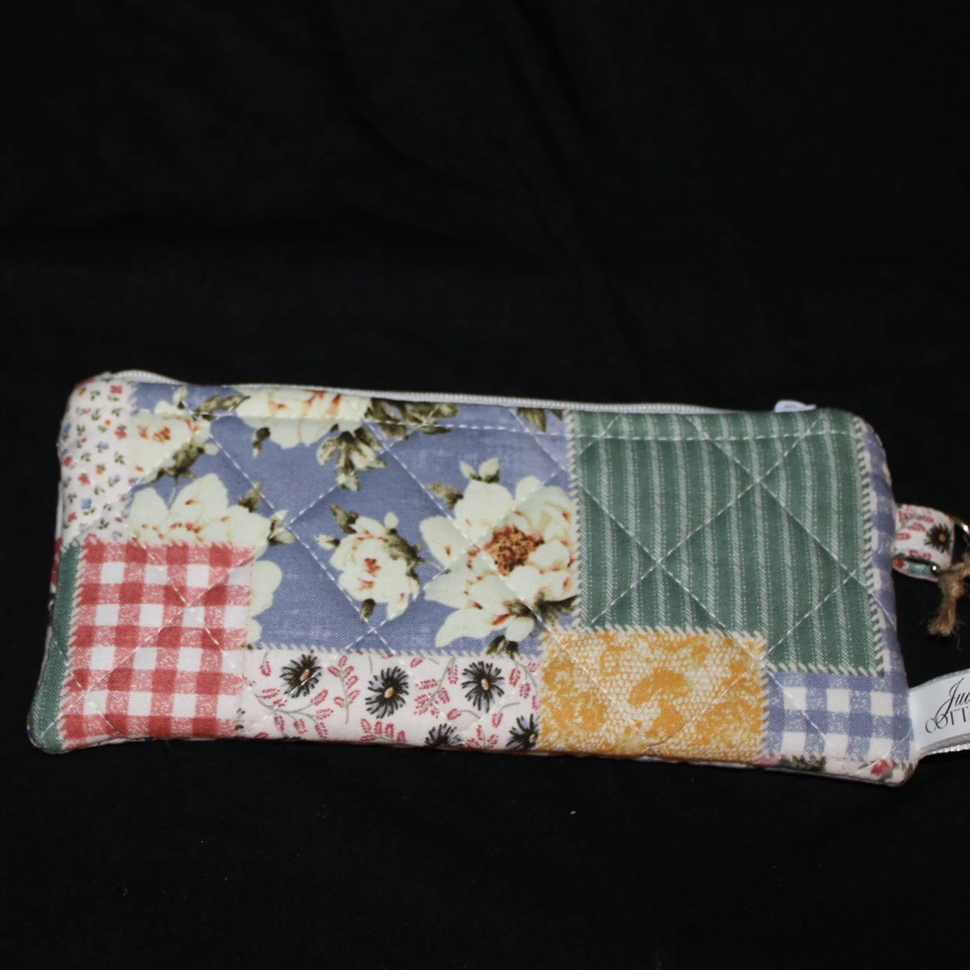 Front flat view of the Serenity Large Keychain Wallet featuring an array of spring colors and florals on patchwork print fabric.
